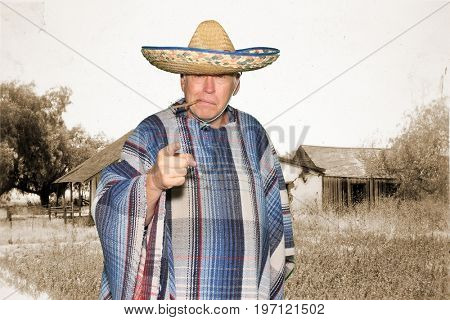 a man wears a sombrero and a serape while posing in a photo booth against a green screen or chroma key background  