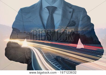 Double exposure from a businessman with a cityscape at dusk and lighttrails. Vintage toned.