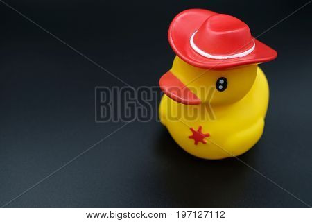 a squishy bright yellow plastic model duck on black background