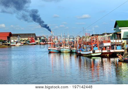 Group of wooden fishery boats stop at the estuary habor in Thailand photo with outdoor sun lighting.