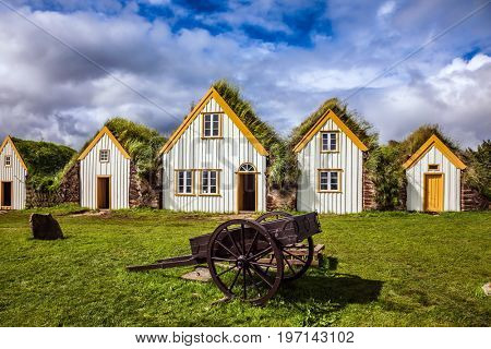 Facade of the farmhouse and ancient rural  wheelbarrow. The concept of the historical and cultural tourism. Ethnographic Museum-estate Glaumbaer, Iceland