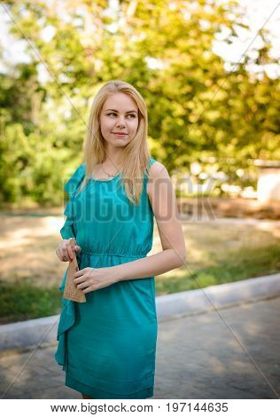 Young blonde girl walking in the park