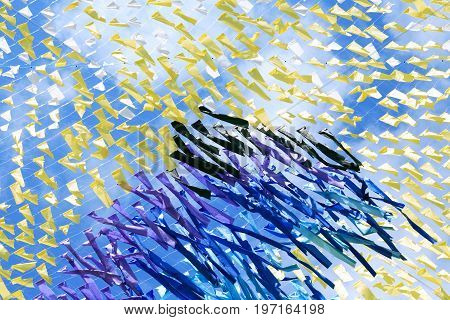 Abstract colorful background made from lot of diversity cloth against blue sky