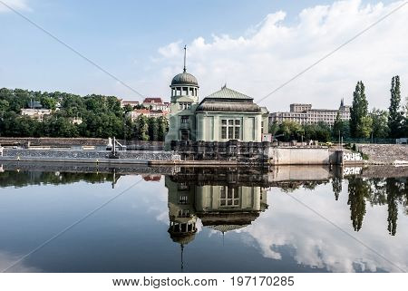 Praha Сzech republic - July 6 2017: building of Vodni elektrarna built in 1912-1913 and designed by architect Alois Dlabac on Stvanice isle reflecting on Vltava river in Prague in Czech republic during summer day with blue sky and clouds
