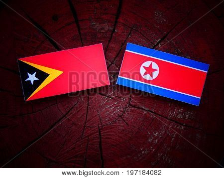 East Timorese Flag With North Korean Flag On A Tree Stump Isolated