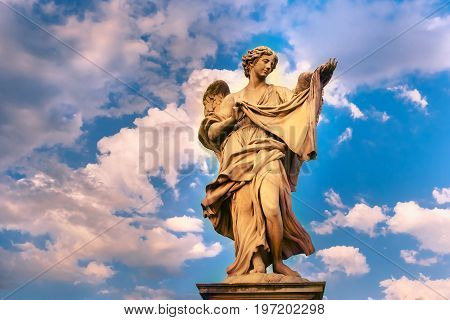 Marble statue of Angel with the Sudarium at sunset, one of the ten angels on Saint Angel Bridge, symbols of Christ's Passion, Rome, Italy