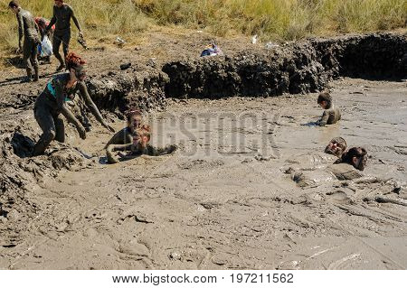 Kuchugury, Russia - July 16, 2017: Azov scorching heat mud volcano. People take procedures with healing mud