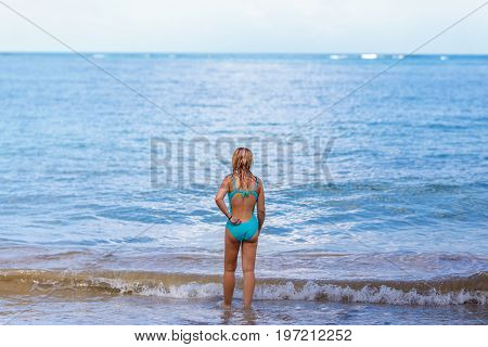 back view of the girl in blue comes to the sea
