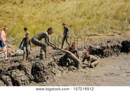 Kuchugury, Russia - July 16, 2017: Azov scorching heat mud volcano. People take procedures with healing mud