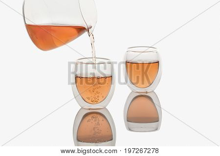Tea pouring into Double-wall Glass Tea Cup, isolated in white