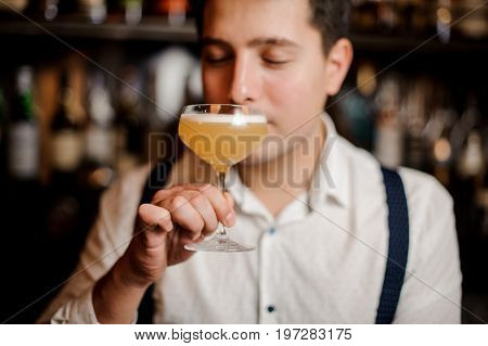 bartender is holdind cocktail with closed eyes