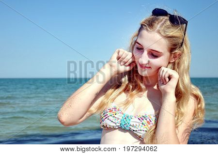 Girl with long hair smiling at the beach