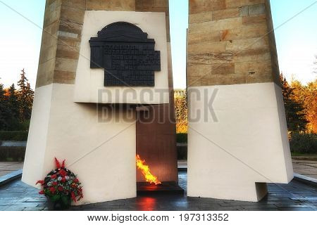 MOSCOW RUSSIA - OCTOBER 13 2015: Eternal flame and obelisk at MSU. Caption on black bas relief from russian: For students and teachers of Moscow state University fallen in battle for Soviet Motherland in great Patriotic war 1941-1945