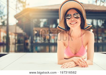 Young female in the swimming pool sunbathing