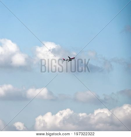 Bologna Italy - October 21 2016: Wizz air airplane flying high in the sky with white clouds Bologna Italy