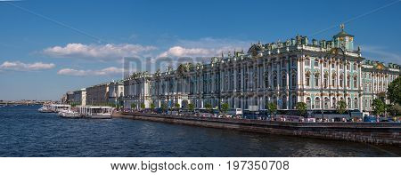 Hermitage palace on the bank of Neva river. On the waterfront there are many tour buses. The waterfront is moored excursion boats. Saint Petersburg, Russia.