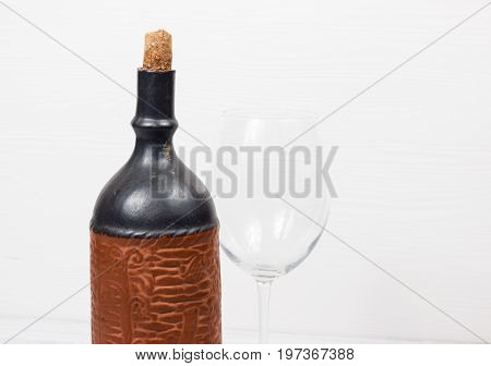 Black bottle of wine and wneglass on the background of the canvas