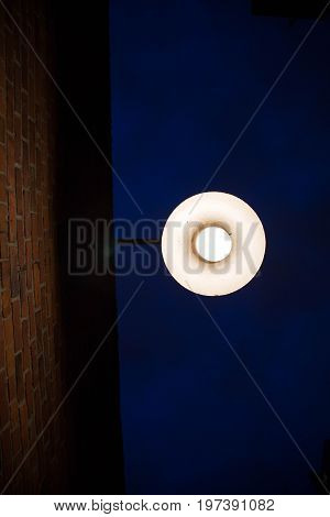 Contrast darness brightness orange bricks wall exterior street lantern
