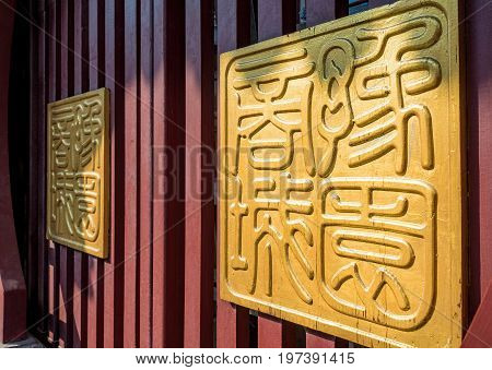 Shanghai, China - Nov 6, 2016: Fangbang Middle Road - Two huge golden Chinese traditional seals (with old-style Chinese characters) on wooden gates.