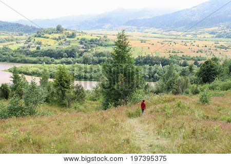 Boy walks picturesque hills of Carpathians. Schodnica Ukraine