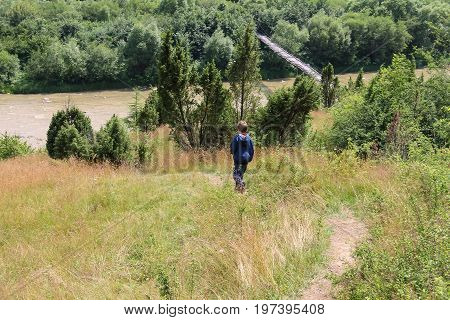 Boy walks picturesque hills of Carpathians. Schodnica Ukraine