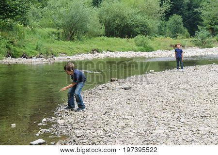 Two boys near mountain river in Carpathians Ukraine