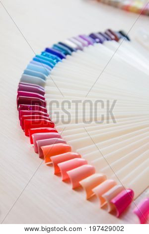Samples of colored nail polish on a white table. Nail salon.