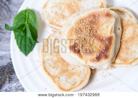 Pancakes With Apples Decorated With Mint And Brown Sugar