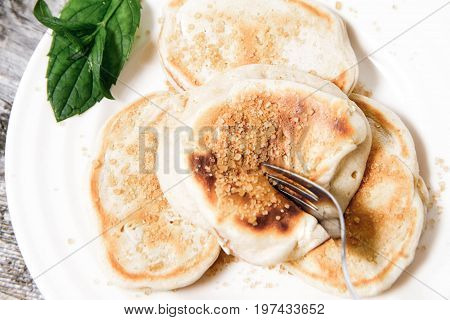 Pancakes With Apples Decorated With Mint And Brown Sugar