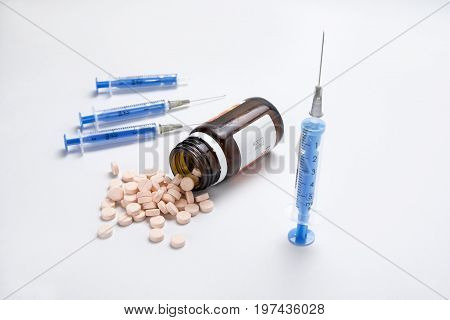 Injections with needles and pills on the whitw background