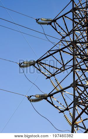 Supports high-voltage power lines against the blue sky. Electrical industry.
