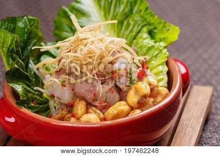 Fresh salad with lupini beans and raw fish served with lettuce leaf in bowl on table napkin