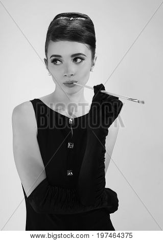 beautiful young woman in retro style with her hair in little black dress