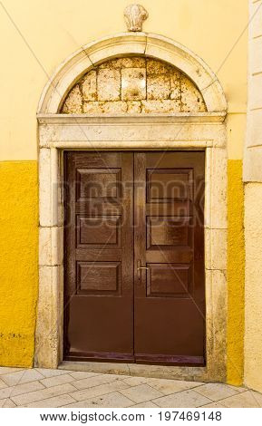 Old broken entrance door to a house on stone street in Istria, Croatia, Europe.