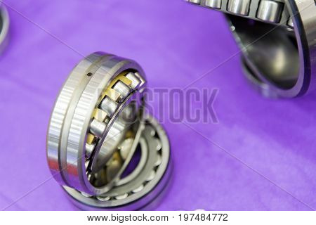 The metal ball bearing spare part on the violet carpet.The hi-precision mechanical part.