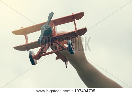 Child Hand Holding Wooden Handmade Airplane