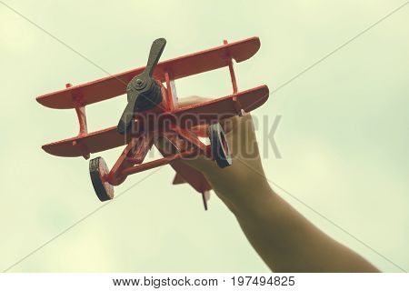 Child Hand Holding Wooden Handmade Airplane