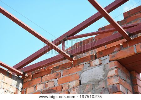 Steel roof trusses corner details. Roofing Construction. Steel roof trusses sitting on concrete pole view from inside.