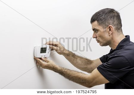 Hvac technician installing faceplate on a digital thermostat
