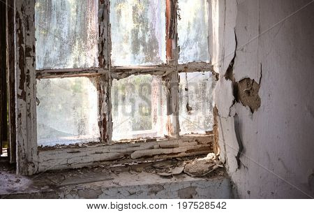 Old window with shabby cracked paint In the old forgotten house