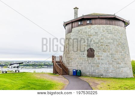 Quebec City Canada - May 30 2017: Martello tower watchtower in plaines d'Abraham with sign and cannon overlooking the Saint Lawrence river