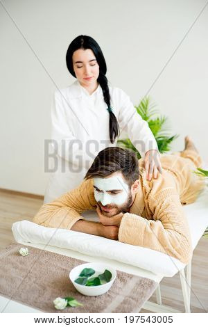 Man relaxing on massage table in spa salon