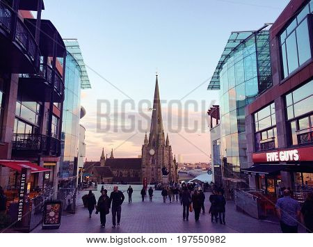 Birmingham, United Kingdom - April 1, 2016: St Martins cathedral in Birmingham, tourists walking on the pedestrian street