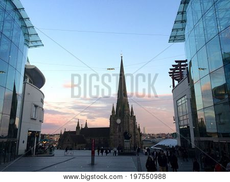 Birmingham, United Kingdom - April 1, 2016: St Martins cathedral in Birmingham, tourists walking on the pedestrian street