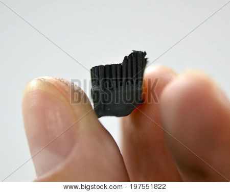 A man holds in his hand an object crown printed on a 3d printer that prints metal close-up