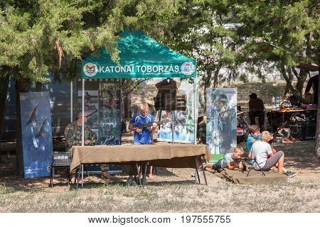 KELEBIA HUNGARY - JULY 23 2017: Hungarian solider letting children play with automatic guns during a recruiting session of the Hungarian Defence Force (Magyar Honvedseg) near the border with Serbia