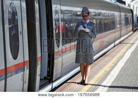 MOSCOW/ RUSSIA - JUNE 30, 2017. The train conductor waiting for the passengers of the high speed electric train Sapsan between Moscow and Saint Petersburg. Moscow, Russia