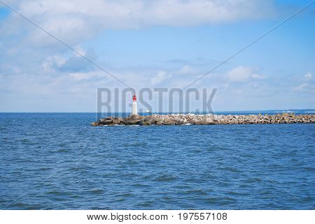 Red and white lighthouse in a jetty pier