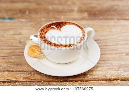 A cup of latte coffee top view on old wood background.