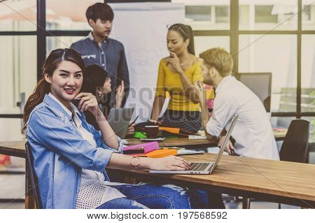 Portrait of Businesswoman working with computer over the photo blurred of Group Of Asian and Multiethnic Business people with casual suit in the modern Office people business group concept